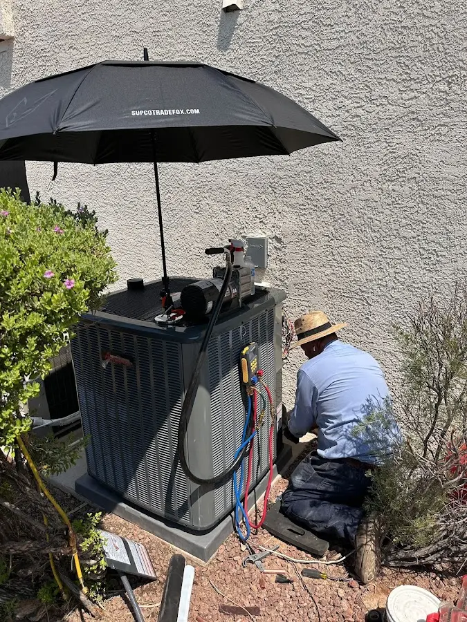 HVAC technician performing outdoor AC maintenance in Falmouth